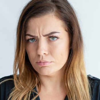Angry pretty woman looking at camera and frowning